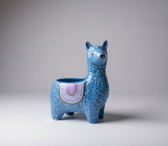 Blue ceramic llama-shaped planter on a gray background