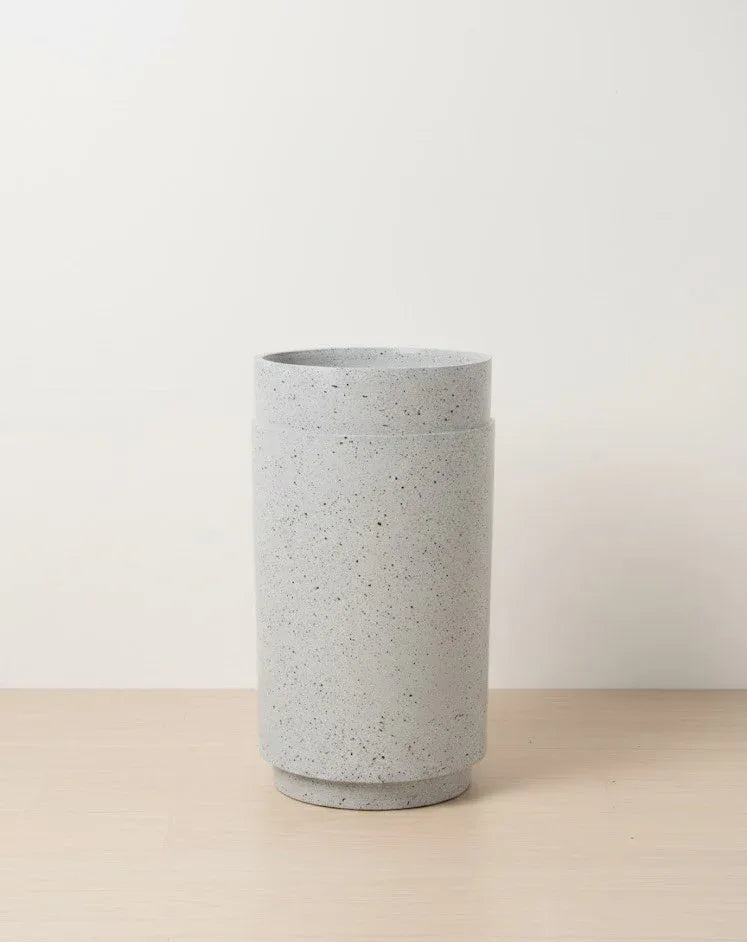 Gray terracotta pot on a beige surface with a light gray background