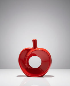 Red apple-shaped object on a white platform with a gray background
