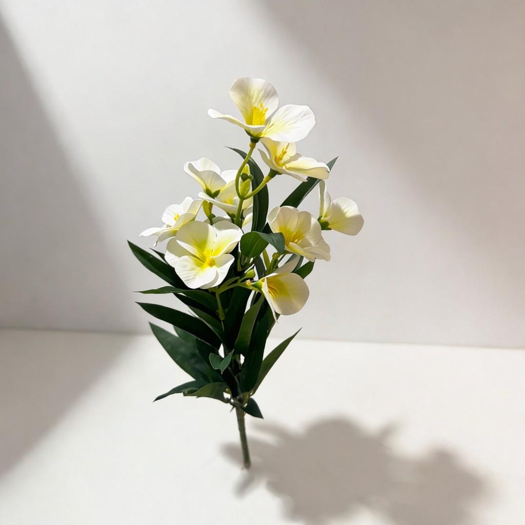 Bouquet of white flowers with green leaves on a light background
